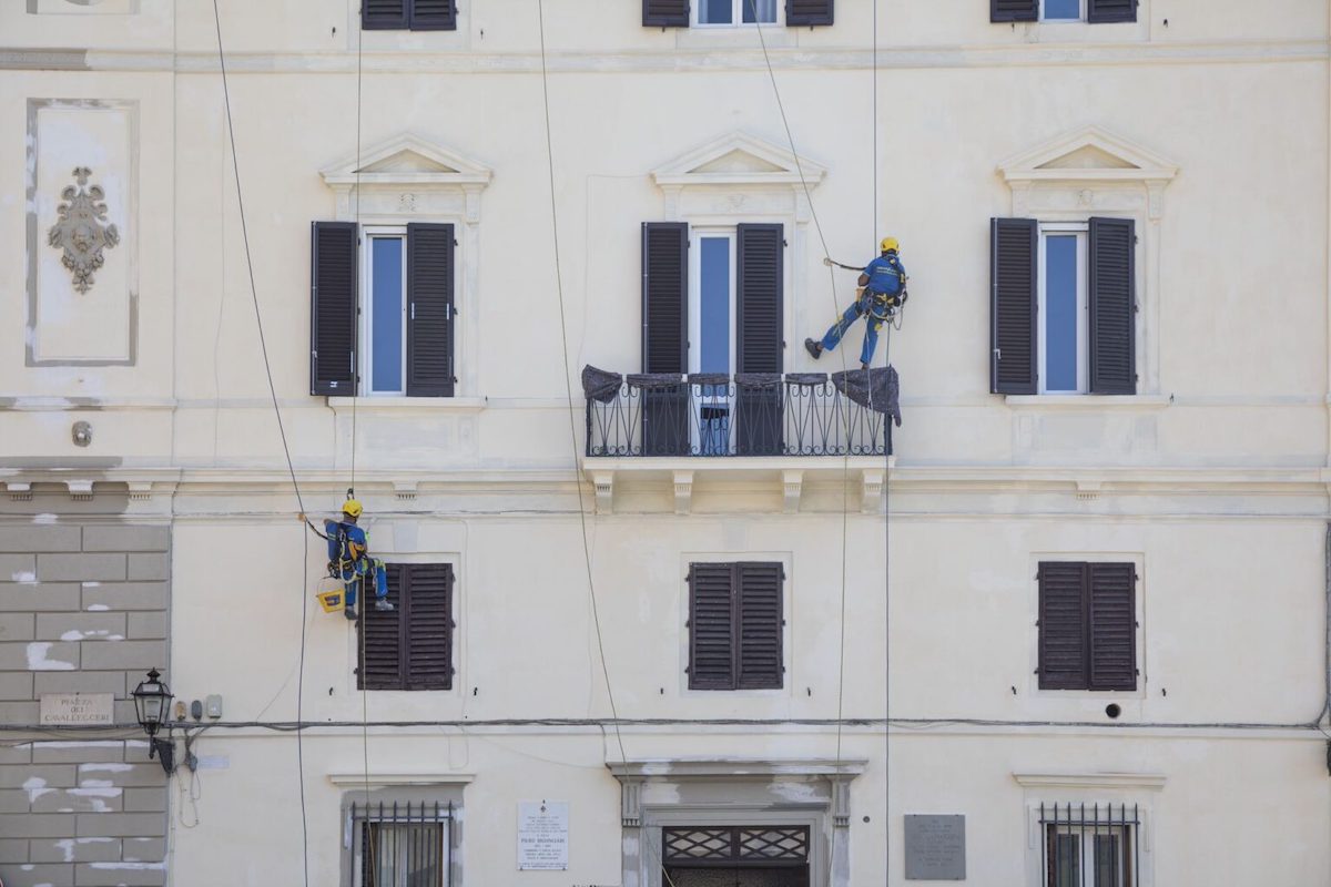 Operai EA durante la ristrutturazione di una facciata 
