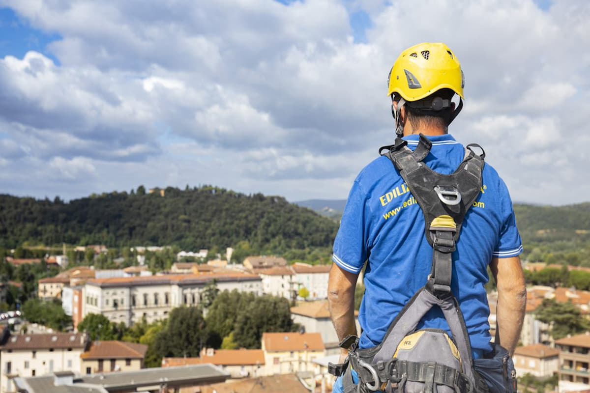 Operaio di spalle. Immagine repertorio per articolo: spessore di un cappotto termico.