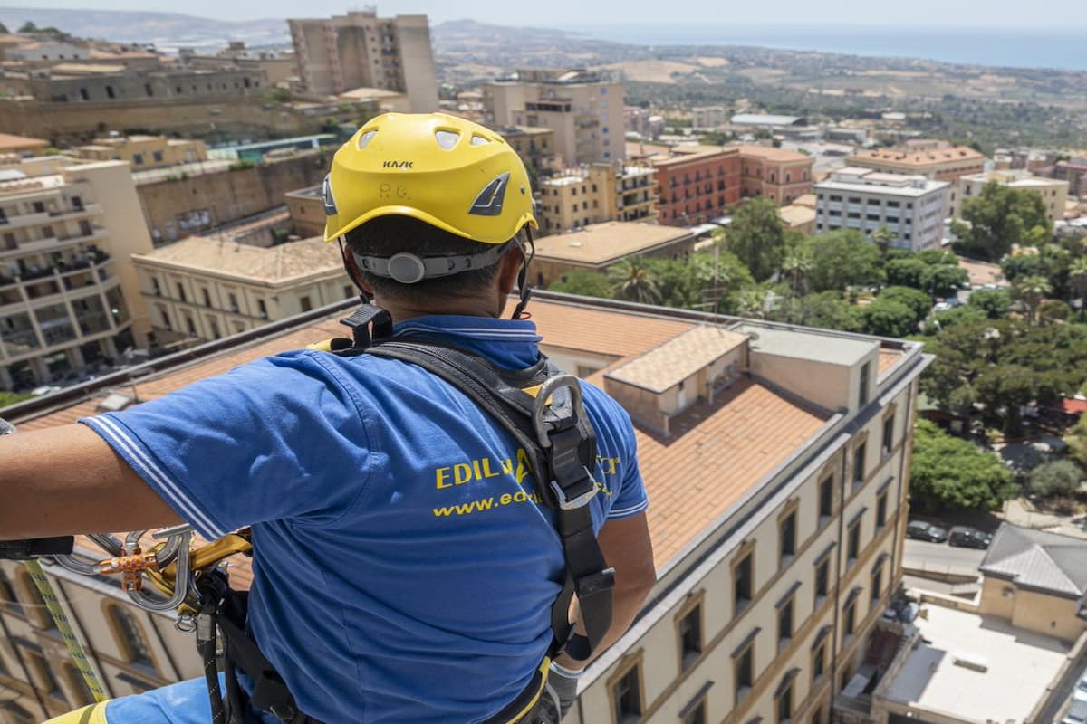 operaio acrobatica di spalle su terrazza